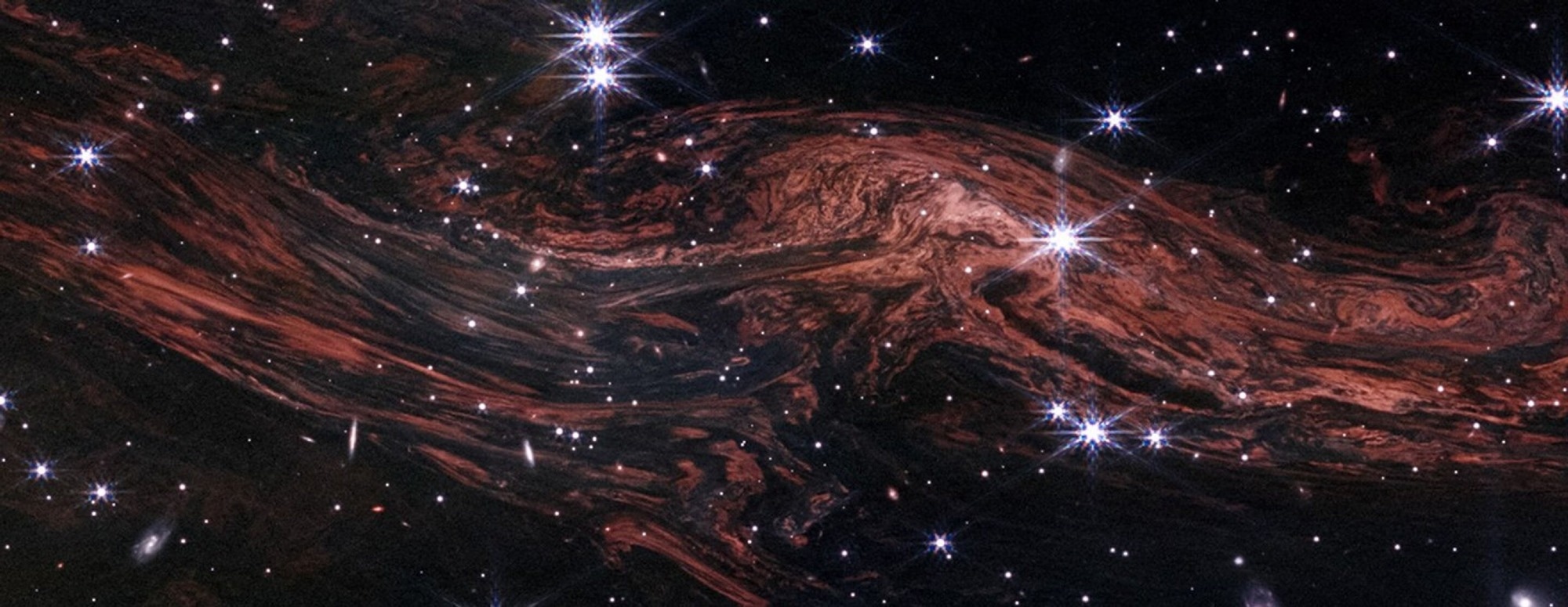 This shimmering cosmic curtain shows interstellar gas and dust that has been heated by the flashbulb explosion of a long-ago supernova