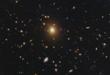 Merging Black Holes Linked to Monster Galaxy’s Puffy Core